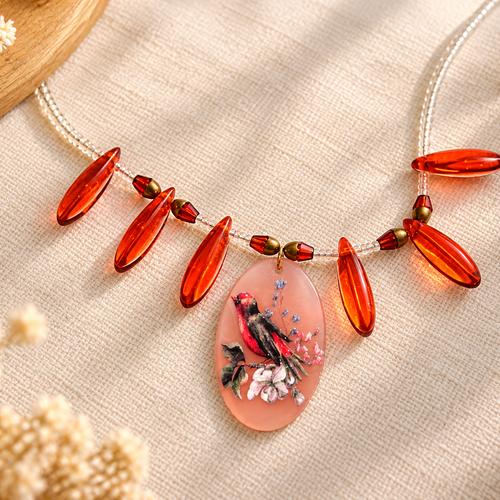 Collier fantaisie oiseau et fleurs – perles de verre orange et rocailles – pendentif acrylique rose