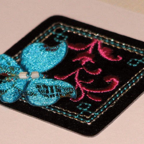 Motif thermocollant  pour fille, forme carré noir et papillon bleu. 