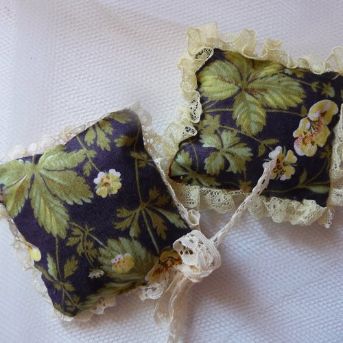 2 coussinets decoratifs en tissus fleuris et dentelles - fond bleu fonce avec fleurs et feuillages