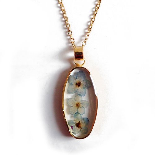 Collier fleur séchée ovale sur chaîne dorée