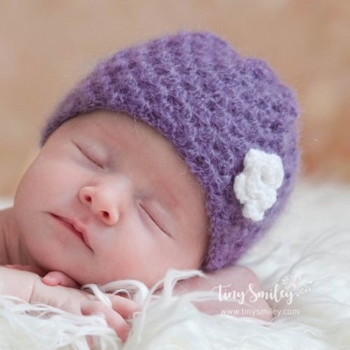 Bonnet bébé crocheté en violet avec une jolie fleur blanche