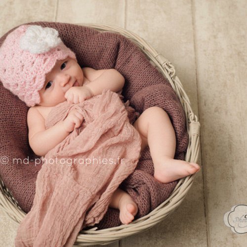 Bonnet bébé crocheté pour fille en rose pâle avec une fleur blanche