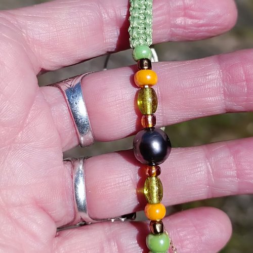 Bracelet point macramé en coton peigné vert clair orné d'une très belle perle de tahiti et de perles de verre colorées.
