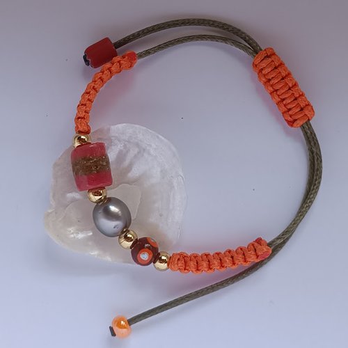 Bracelet orange, mêlant l'éclat d’une perle de tahiti à la brillance de l’or et aux couleurs de l'afrique