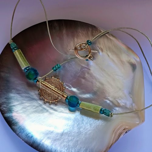 Collier ethnique sur cuir avec perle tribale en laiton du ghana, perles africaines aux reflets verts et bleus et oursins crayons verts
