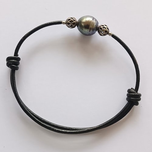 Bracelet homme et perle de tahiti véritable sur cordon de cuir noir réglable, entourée de deux perles argentées vieillies filigranées.