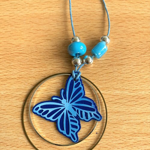 Sautoir composé de deux cercles en métal autour d'une forme en cuir véritable - modèle papillon