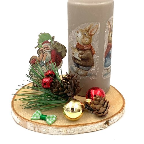 Centre de table composé d'une bougie de 12 cm ornée de lapins et d'un décor de noel avec le père noël