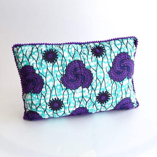 Coussin décoratif rectangle ethnique en wax africain graphique violet et bleu turquoise avec bordure en petit pompon