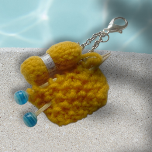 Bijou de sac en pelote de laine avec petit tricot commencé couleur jaune