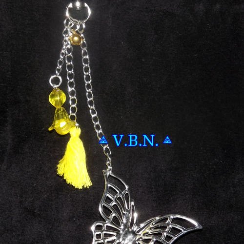 Bijoux de sac metal argente avec papillon fleur mini grelot et pompon jaune 