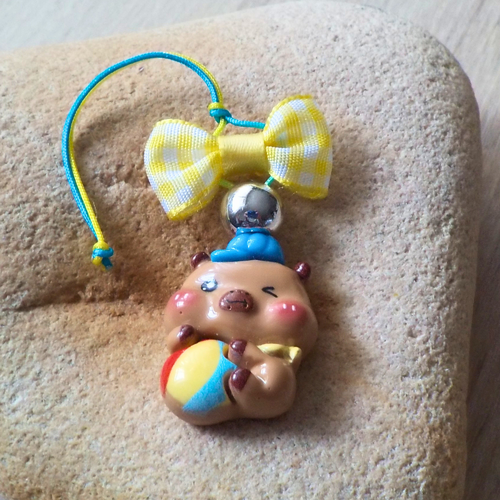 Bijou de portbale capybara bébé et son ballon multicolore surmonté d'un noued jaune vichy en tissu
