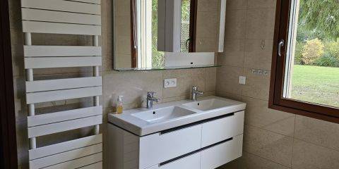Salle de bain spacieuse avec baignoire, grande douche et double vasque